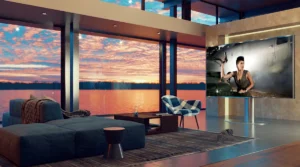 A sunset-scenery living room with spacious couch in front of big TV screen.