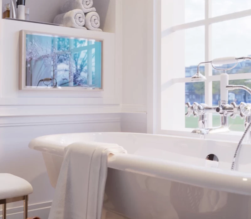 A stylish TV on a serene space with a simple white bathtub.