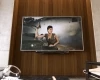 TV showing a woman holding a gun displayed against a living room wall icon.